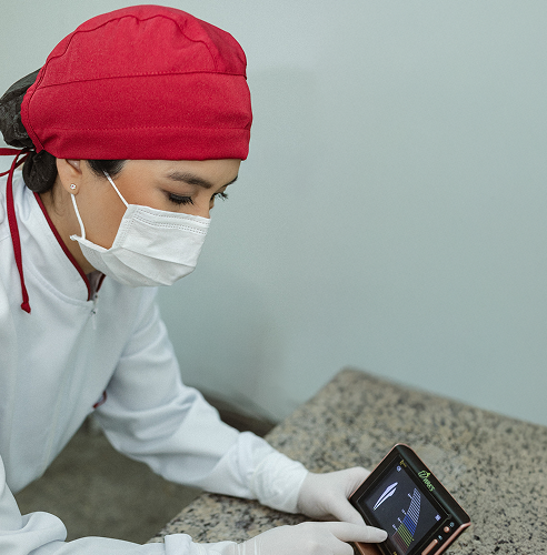 Foto da Dra. Mayra apontando um equipamento endodôntico