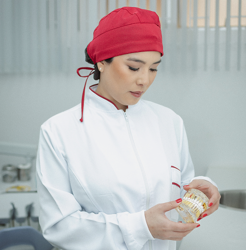 Foto da Dra. Mayra segurando um modelo de boca