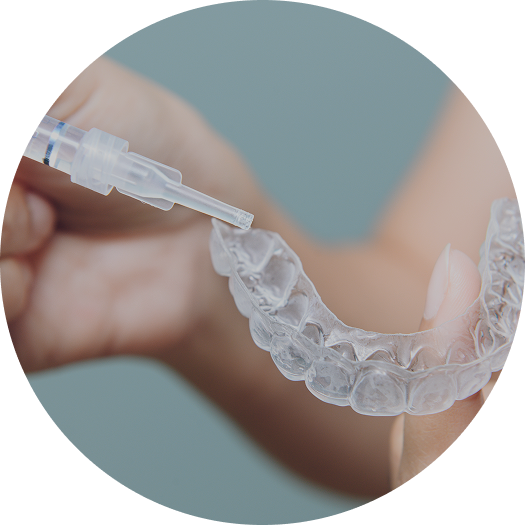 Imagem de uma placa e seringa para clareamento dental